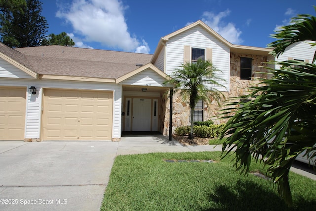9027 Manchester Ln Unit 22F, West Melbourne, FL 32904 - view of front of house with stone siding, concrete driveway, and an attached garage