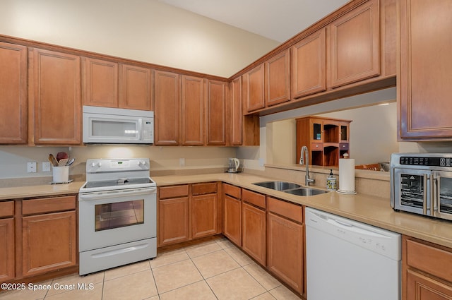 1869 Tullagee Ave, Melbourne, FL 32940 - kitchen featuring white appliances, light tile patterned floors, light countertops, and brown cabinetry