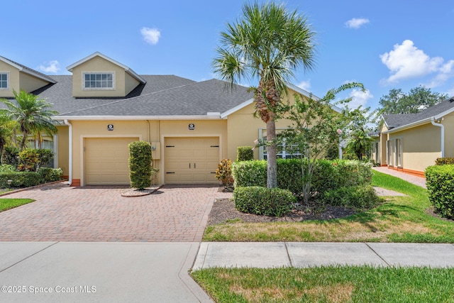 2690 Camberly Cir, Melbourne, FL 32940 - townhome / multi-family property featuring decorative driveway, a garage, a shingled roof, and stucco siding