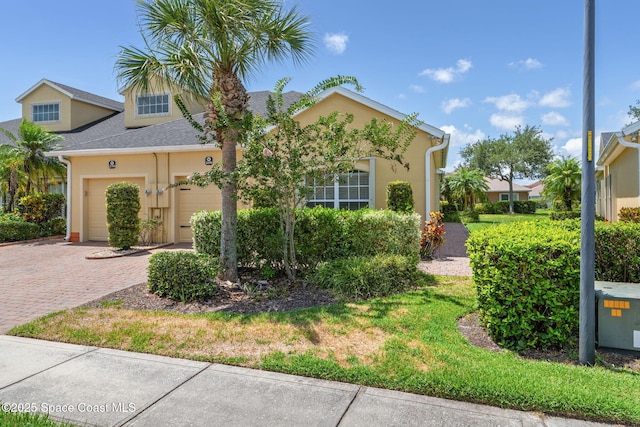 2690 Camberly Cir, Melbourne, FL 32940 - view of front of property featuring decorative driveway, stucco siding, an attached garage, and a shingled roof
