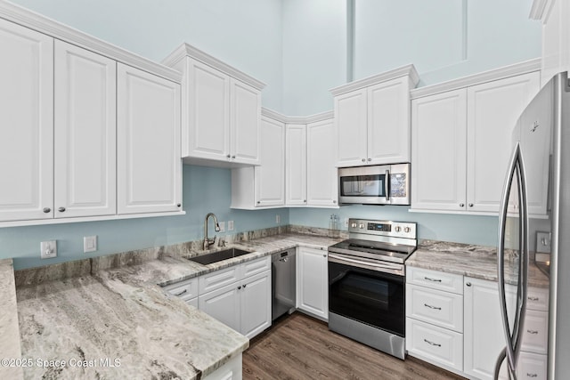 2690 Camberly Cir, Melbourne, FL 32940 - kitchen with stainless steel appliances, white cabinets, light stone counters, and dark wood-type flooring