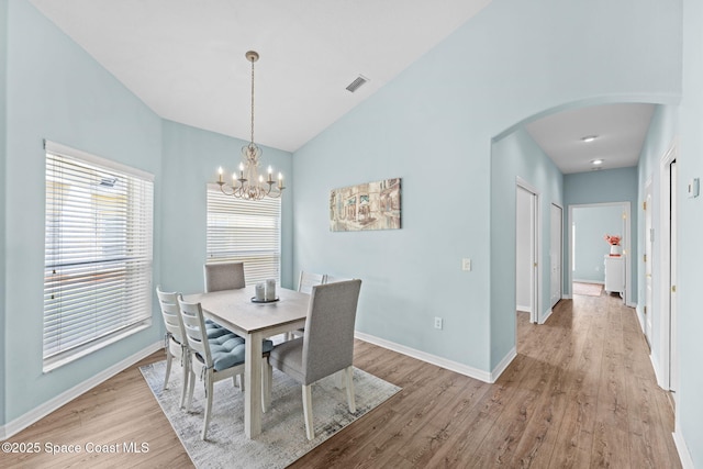 2690 Camberly Cir, Melbourne, FL 32940 - dining space with arched walkways, wood finished floors, lofted ceiling, and a chandelier