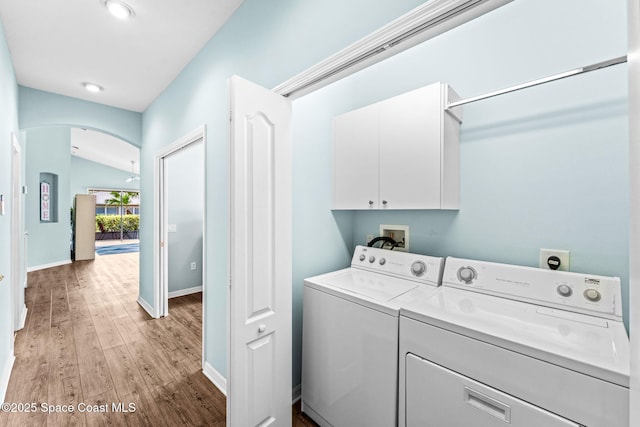 2690 Camberly Cir, Melbourne, FL 32940 - laundry room featuring arched walkways, cabinet space, washing machine and clothes dryer, light wood-style floors, and recessed lighting