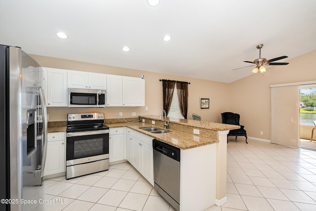 2383 Glasbern Cir, Melbourne, FL 32904 - kitchen featuring appliances with stainless steel finishes, a peninsula, light tile patterned floors, white cabinets, and vaulted ceiling