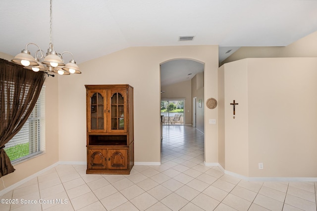 2383 Glasbern Cir, Melbourne, FL 32904 - spare room featuring lofted ceiling, a chandelier, light tile patterned flooring, and arched walkways