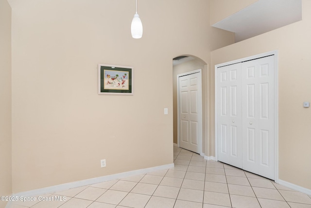 2383 Glasbern Cir, Melbourne, FL 32904 - unfurnished bedroom featuring arched walkways, a closet, and light tile patterned flooring