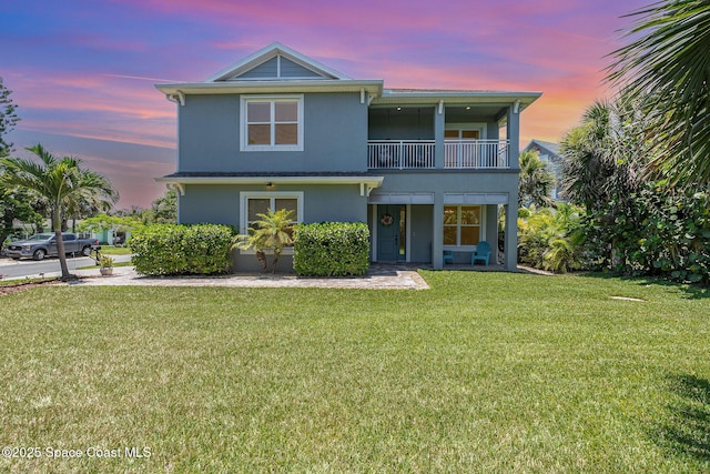 120 Heron Dr, Melbourne Beach, FL 32951 - view of front facade with a balcony, stucco siding, and a front lawn
