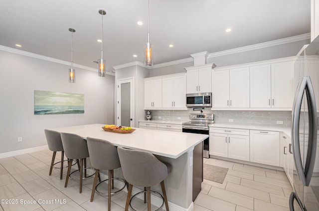 120 Heron Dr, Melbourne Beach, FL 32951 - kitchen featuring appliances with stainless steel finishes, decorative backsplash, crown molding, light countertops, and a center island