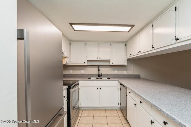 964 Mcfarlan Ave, Fort Walton Beach, FL 32547 - kitchen with appliances with stainless steel finishes, white cabinetry, light tile patterned flooring, light countertops, and ventilation hood