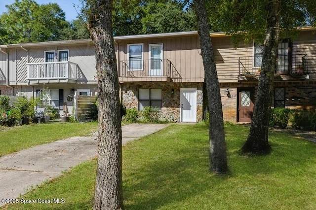 964 Mcfarlan Ave, Fort Walton Beach, FL 32547 - view of property with stone siding, a front yard, and a balcony