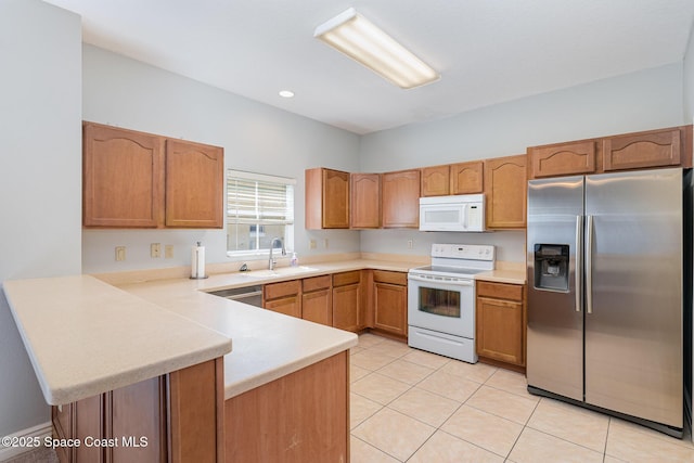 609 Cedar Side Cir NE, Palm Bay, FL 32905 - kitchen with white appliances, a peninsula, light countertops, light tile patterned floors, and brown cabinetry