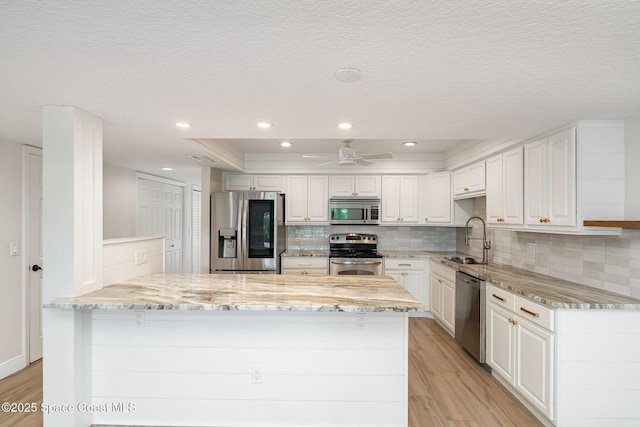 1708 Atlantic St Unit 4F, Melbourne Beach, FL 32951 - kitchen featuring appliances with stainless steel finishes, light wood finished floors, light stone counters, recessed lighting, and a textured ceiling
