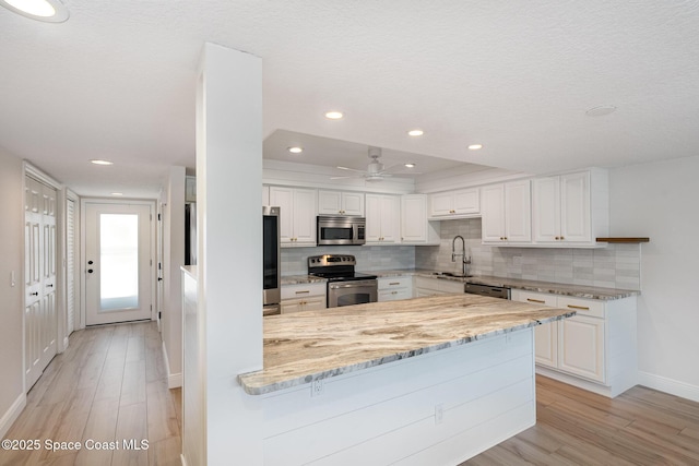 1708 Atlantic St Unit 4F, Melbourne Beach, FL 32951 - kitchen with stainless steel appliances, a peninsula, tasteful backsplash, light stone counters, and recessed lighting