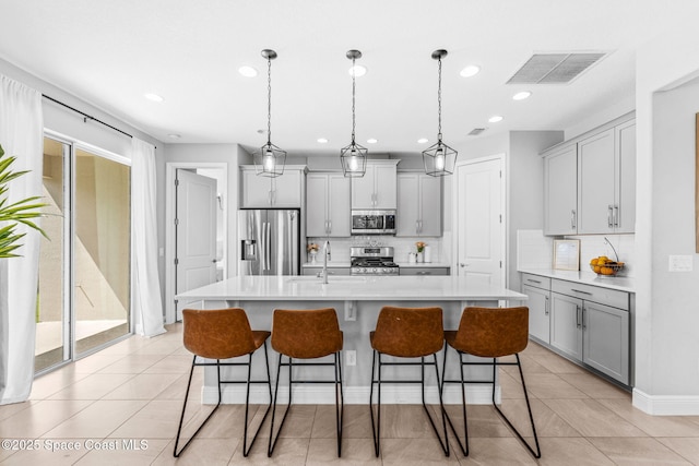 3089 Ribbon Grass Dr, Melbourne, FL 32940 - kitchen with stainless steel appliances, gray cabinets, decorative backsplash, recessed lighting, and light countertops