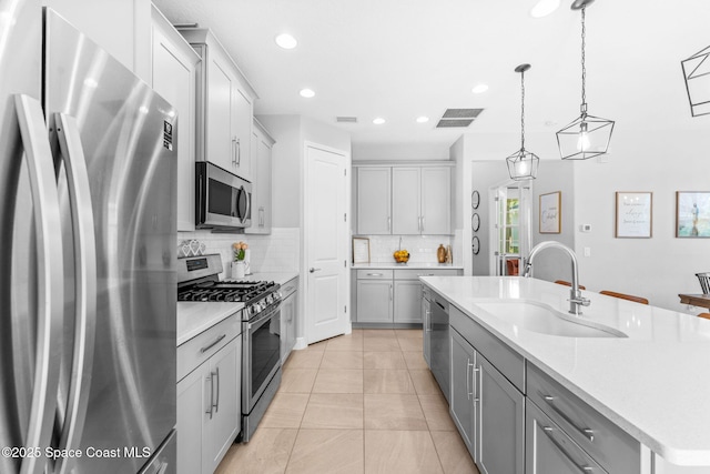 3089 Ribbon Grass Dr, Melbourne, FL 32940 - kitchen featuring stainless steel appliances, gray cabinets, light countertops, an island with sink, and recessed lighting