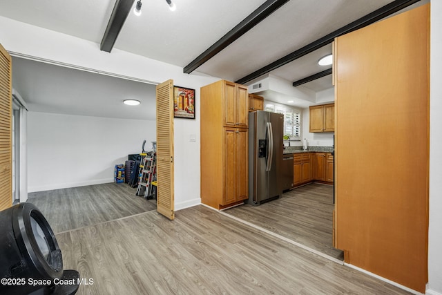 1056 Noreen Blvd, Rockledge, FL 32955 - kitchen with stainless steel appliances, beamed ceiling, light wood finished floors, brown cabinets, and dark countertops