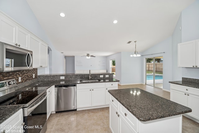183 Frante Ave NE, Palm Bay, FL 32907 - kitchen featuring stainless steel appliances, vaulted ceiling, a ceiling fan, white cabinets, and backsplash