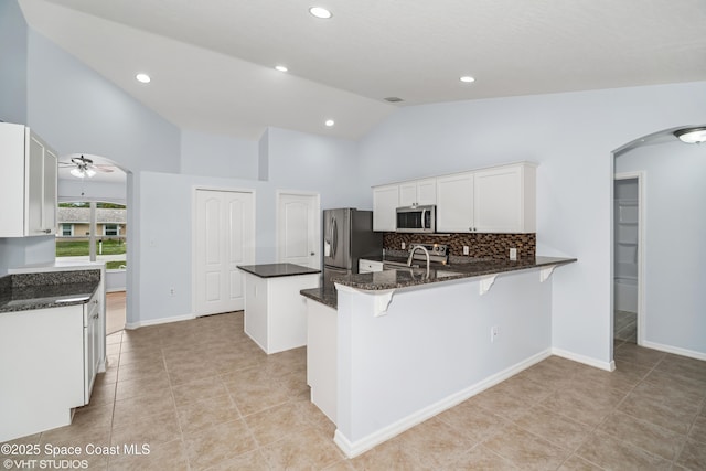 183 Frante Ave NE, Palm Bay, FL 32907 - kitchen with stainless steel appliances, arched walkways, a peninsula, a ceiling fan, and a center island
