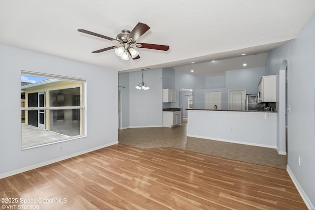 183 Frante Ave NE, Palm Bay, FL 32907 - unfurnished living room featuring light wood finished floors, arched walkways, ceiling fan, lofted ceiling, and recessed lighting