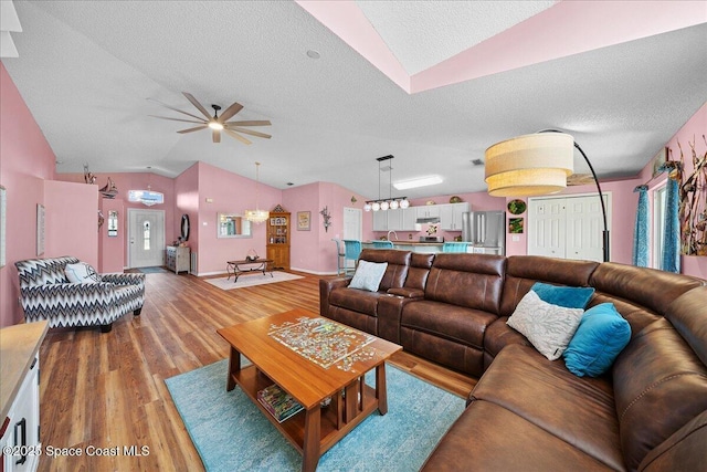 2627 Deercroft Dr, Melbourne, FL 32940 - living room with lofted ceiling, light wood-type flooring, a ceiling fan, and a textured ceiling