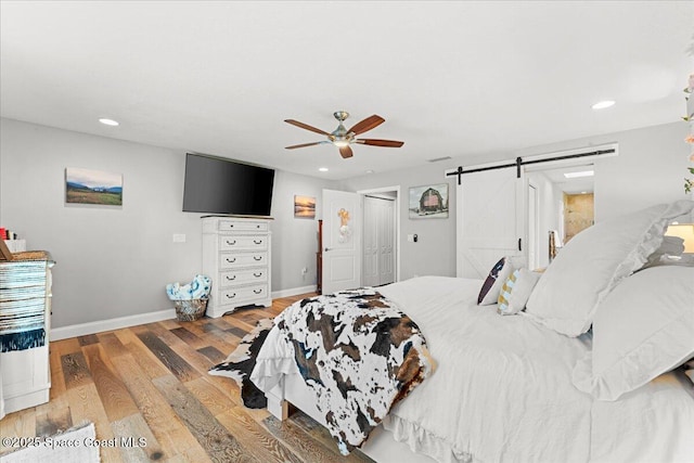 260 Utopia Cir, Merritt Island, FL 32952 - bedroom with wood finished floors, a barn door, recessed lighting, and a ceiling fan