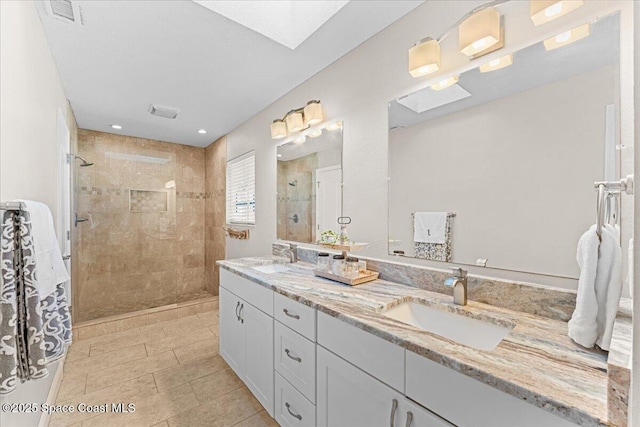 260 Utopia Cir, Merritt Island, FL 32952 - bathroom featuring a tile shower, double vanity, tile patterned flooring, recessed lighting, and a skylight