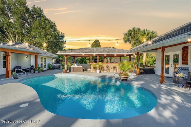 260 Utopia Cir, Merritt Island, FL 32952 - pool at dusk featuring french doors, an outdoor pool, and a patio area