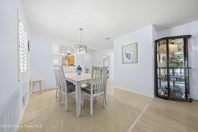 743 Palm Springs Cir, Satellite Beach, FL 32937 - dining space featuring a chandelier and baseboards