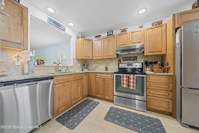 743 Palm Springs Cir, Satellite Beach, FL 32937 - kitchen with appliances with stainless steel finishes, under cabinet range hood, backsplash, light stone countertops, and recessed lighting