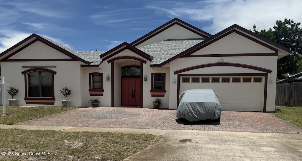240 Sheridan Ave, Satellite Beach, FL 32937 - view of front of home featuring roof with shingles, stucco siding, decorative driveway, and an attached garage
