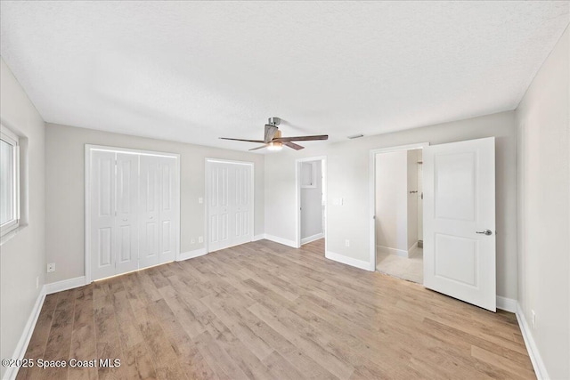 203 6th Ave Unit 9, Melbourne Beach, FL 32951 - unfurnished bedroom featuring light wood-type flooring, two closets, and a ceiling fan
