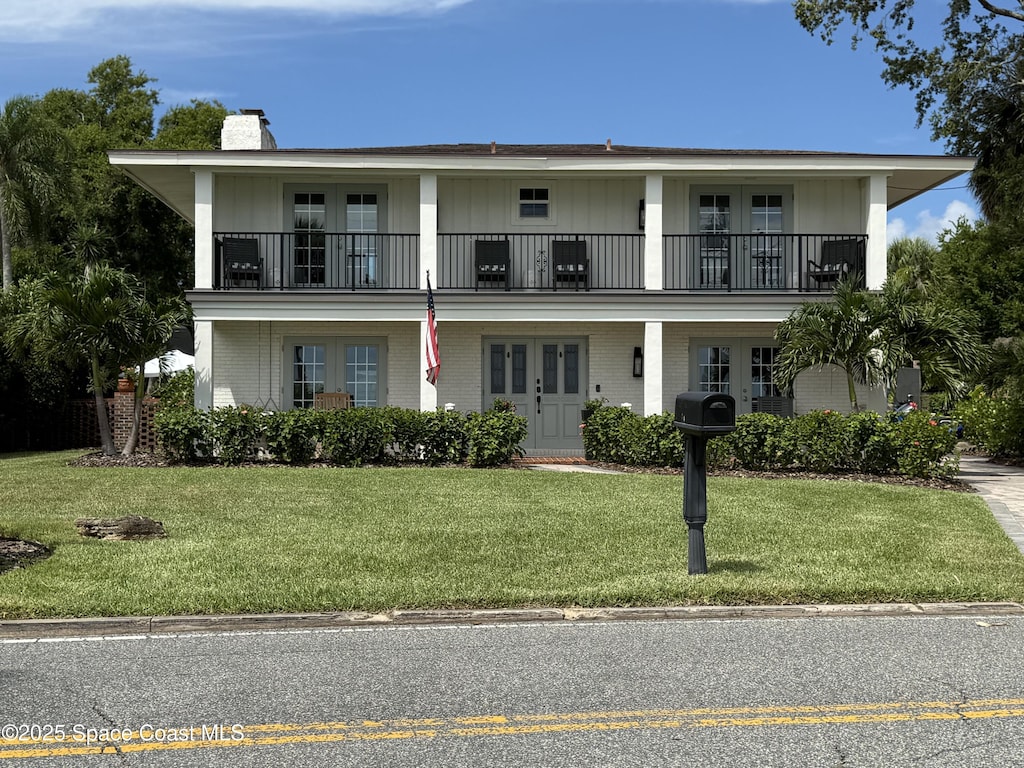 1307 Rockledge Dr, Rockledge, FL 32955 - view of front facade featuring french doors, a balcony, a chimney, and brick siding