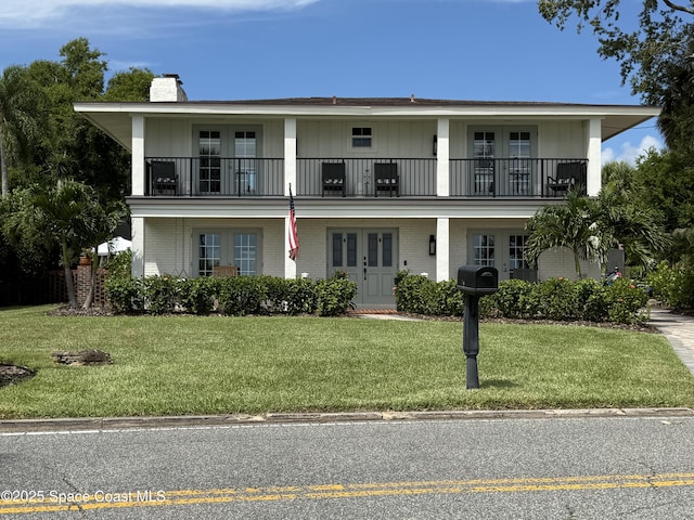 1307 Rockledge Dr, Rockledge, FL 32955 - view of front facade featuring french doors, a balcony, a chimney, and brick siding