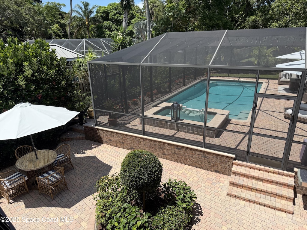 1307 Rockledge Dr, Rockledge, FL 32955 - view of swimming pool featuring a patio, a pool with connected hot tub, a lanai, and view of scattered trees
