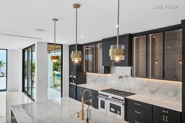 16 Seaside Ave, Key Largo, FL 33037 - kitchen with decorative backsplash, modern cabinets, double oven range, light stone countertops, and floor to ceiling windows