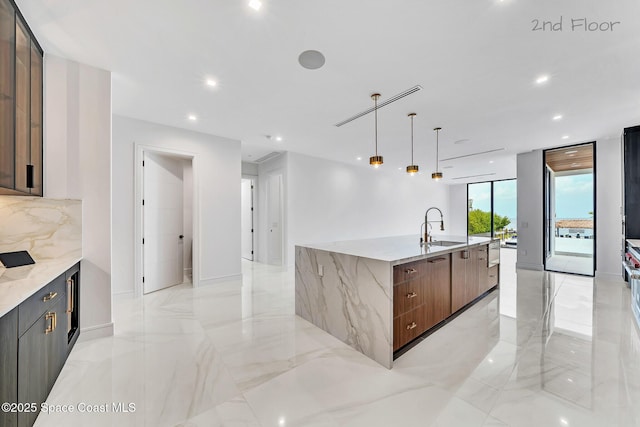 16 Seaside Ave, Key Largo, FL 33037 - kitchen featuring modern cabinets, a large island with sink, decorative backsplash, light stone countertops, and recessed lighting