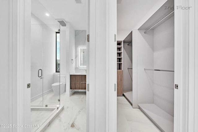 16 Seaside Ave, Key Largo, FL 33037 - full bathroom featuring marble tiled floors, a spacious closet, vanity, and a stall shower