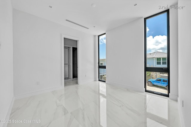 16 Seaside Ave, Key Largo, FL 33037 - empty room with healthy amount of natural light and marble finish floors