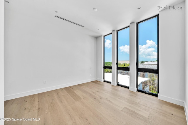 16 Seaside Ave, Key Largo, FL 33037 - spare room featuring a wall of windows and light wood-style floors