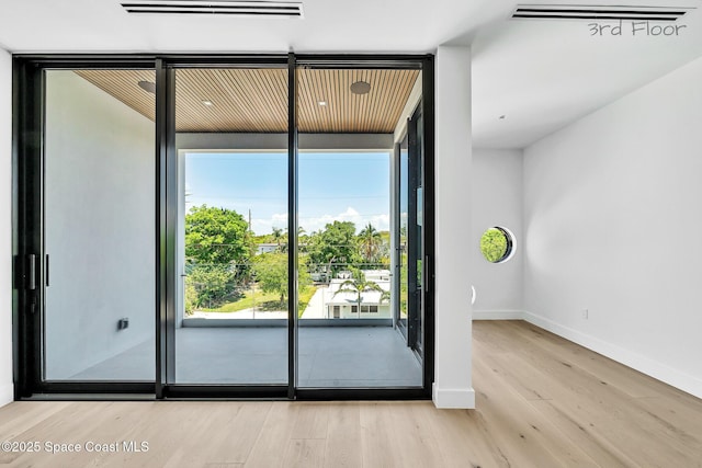 16 Seaside Ave, Key Largo, FL 33037 - unfurnished room featuring wood finished floors, healthy amount of natural light, and a wall of windows