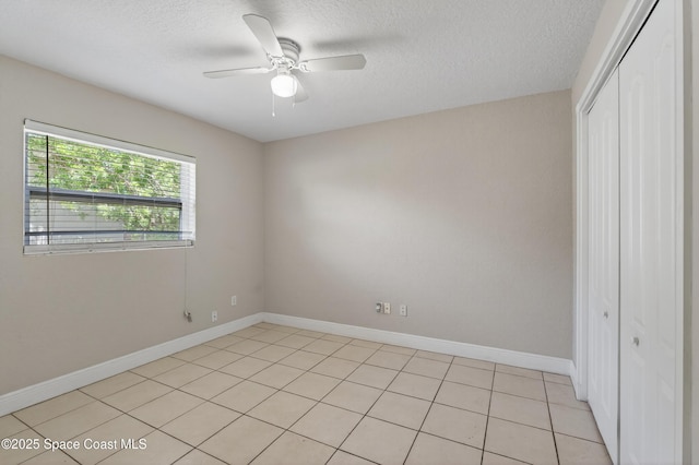959 Macco Rd, Cocoa, FL 32927 - unfurnished bedroom featuring a closet, a textured ceiling, light tile patterned flooring, and a ceiling fan