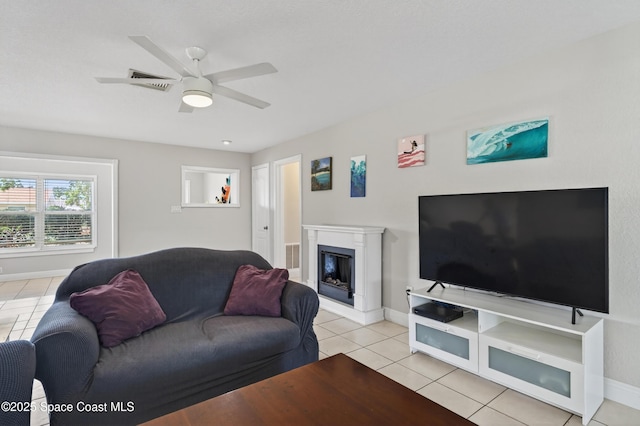 959 Macco Rd, Cocoa, FL 32927 - living area with light tile patterned floors, a glass covered fireplace, and a ceiling fan