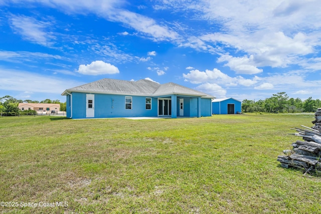 156 Puddle Duck Ln, Grant-Valkaria, FL 32909 - back of house featuring stucco siding and a lawn
