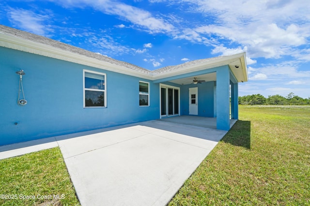 156 Puddle Duck Ln, Grant-Valkaria, FL 32909 - back of property with a yard, stucco siding, a patio area, and a ceiling fan