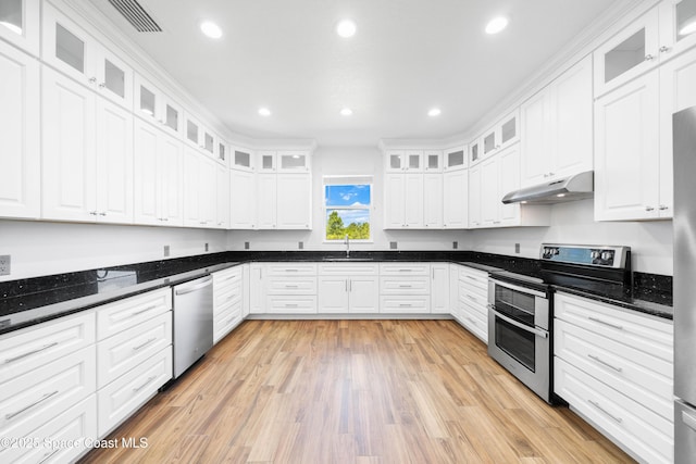 156 Puddle Duck Ln, Grant-Valkaria, FL 32909 - kitchen with stainless steel appliances, under cabinet range hood, white cabinets, light wood finished floors, and recessed lighting