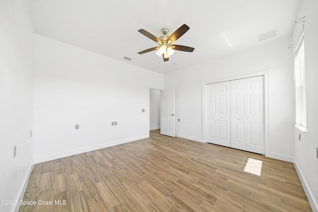 156 Puddle Duck Ln, Grant-Valkaria, FL 32909 - unfurnished bedroom with light wood-type flooring, a closet, and a ceiling fan
