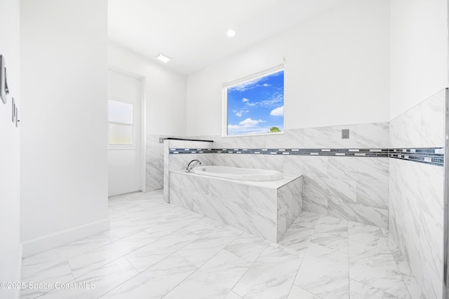 156 Puddle Duck Ln, Grant-Valkaria, FL 32909 - bathroom with marble finish flooring, plenty of natural light, a bath, and tile walls