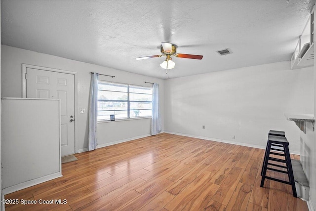 3664 Longbow Rd, Cocoa, FL 32926 - unfurnished living room featuring light wood finished floors, ceiling fan, and a textured ceiling