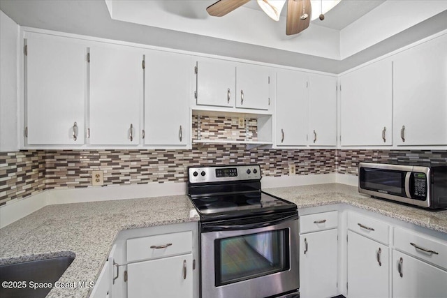 3664 Longbow Rd, Cocoa, FL 32926 - kitchen featuring appliances with stainless steel finishes, light countertops, backsplash, a ceiling fan, and white cabinetry