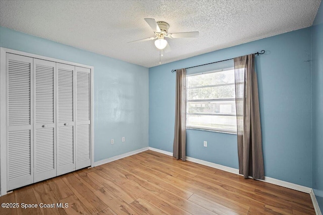 3664 Longbow Rd, Cocoa, FL 32926 - unfurnished bedroom with wood finished floors, a closet, a textured ceiling, and ceiling fan